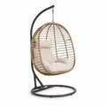 Poltrona sospesa in rattan con struttura in metallo e cuscini beige